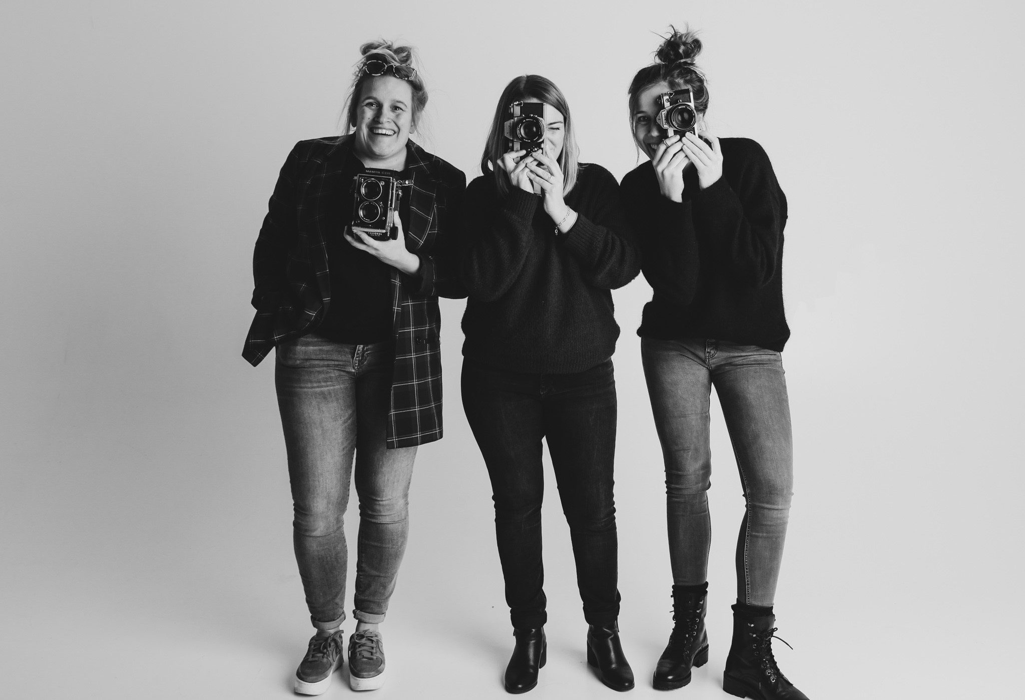 Drie bevriende fotografen met analoge camera's